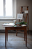 Vintage-style accessories on old stepladder and wooden table on wooden floor