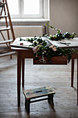 Ivy tendrils, fabric flowers and craft materials on old table