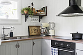 Grey, restored country-house kitchen with L-shaped counter