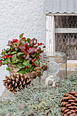 Winter decoration with Gaultheria, pinecones, lantern, and a cypress branch