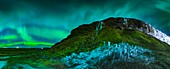Aurora borealis over cliffs in Iceland