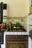 Gasherd und Ofen in einer rustikalen Küche mit grünen Fliesen