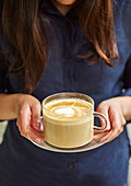 Milchkaffee in Glastasse mit Milchschaumherz