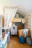 Wooden bed and chest of drawers below loft bed in siblings' bedroom