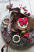 Autumnal arrangement of tree bark, roses, wooden beads and carob pods