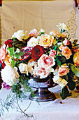 Festive table centrepiece of roses and pomegranates