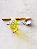 Zutaten zum Ölziehen: Zahnbürste, Esslöffel und Olivenöl