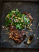 Cola-glazed lamb ribs with a spring onion salad and crunchy buckwheat