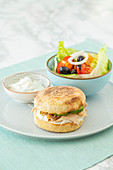 A toast burger with chicken and a colourful salad