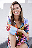 A young woman wearing a brightly patterned summer dress