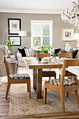 Wooden dining set in open-plan interior with grey wall