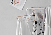 Ladies' clothing hung from white clothes rail