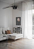 Fan-shaped designer lamp and white chaise couch in living room