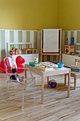 Spielbereich im Kinderzimmer mit Holzstuhl und Ghoststuhl an Maltisch
