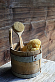 Bath sponge and brush in wooden bucket