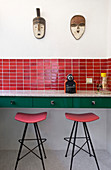 Bar stools under counter in retro red-and-green kitchen