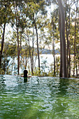 Infinity pool with view of woodland and lake