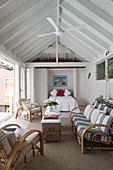 Bamboo sofa and armchairs around wicker coffee table in beach house