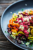 Vegetable noodles made from sweet potatoes with carrots, beetroot pesto and feta cheese