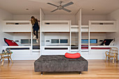 Bunk beds in bedroom with girl climbing down ladder