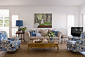 Upholstered furnishings in white, blue and ecru around coffee table in living room