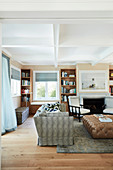 Sofa and leather ottoman in front of fireplace in living room