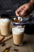 Chai Latte mit Zimtpulver bestäuben