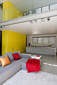 Offener Wohnraum in Architektenhaus mit Galerie und etagenübergreifender gelber Schrankwand