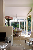 Dining area in glazed conservatory of country-house-style open-plan interior