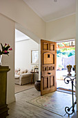 Foyer of country house with open wooden door leading into garden