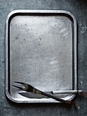 A baking tray with carving cutlery