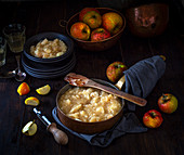 Stewed apples in a pan and bowl with orchard picked apples