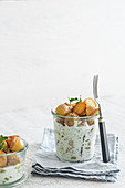Herring salad in glasses with small roasted potatoes