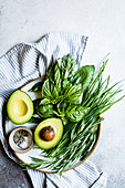 Avocado and herbs on a plate, with copy space