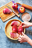Apfeltarte zubereiten: Mürbeteigboden mit Apfelscheiben belegen