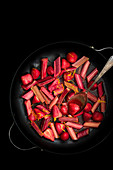 Roasted rhubarb and strawberries in syrup in a pan