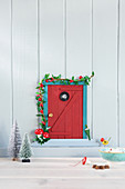 Handmade gnome-sized door on wall as Christmas decoration