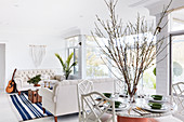 Large arrangement of branches on dining table open-plan interior