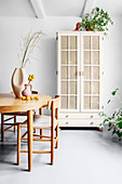 Refurbished cupboard with Viennese cane door panels in dining room