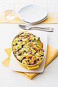 Penne casserole with cooked ham, fava beans and scamorza