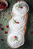 Meringue pastries decorated with red pepper and rosemary