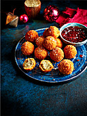 Krokettenbällchen gefüllt mit Bread Sauce serviert mit Cranbeerydip