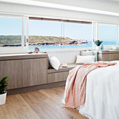 Horizontales Panoramafenster und Sideboard mit Bank im Schlafzimmer
