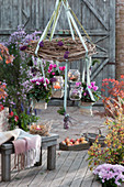 Cyclamen and lanterns hung from a wreath of tendrils, Calluna vulgaris and berries from the love pearl bush as decoration