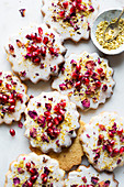 Cookies with icing, pomegranate seeds and rose petals