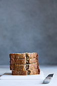 Four slices of banana bread, stacked against a gray background