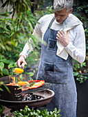 Peppers being grilled over a coal barbecue