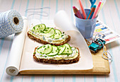 Blackbread topped with cream cheese and cucumber