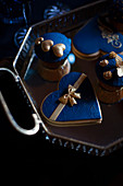 Cupcakes und Plätzchen mit Topping in Dunkelblau und Gold