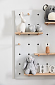 Baby toys in shades of grey on shelves on peg board